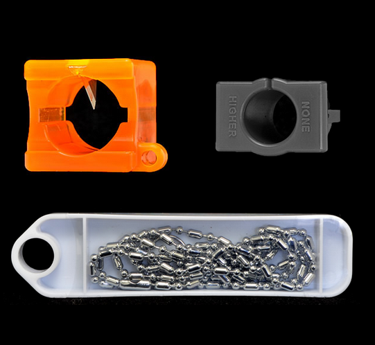 A plastic container with some metal chains and an orange object.